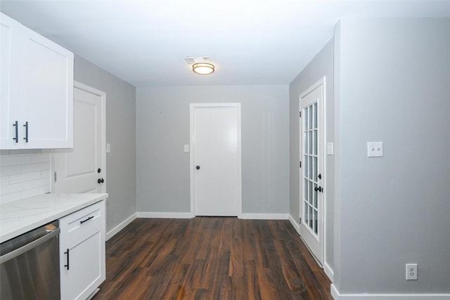 interior space featuring backsplash, dishwasher, white cabinets, and dark wood-type flooring