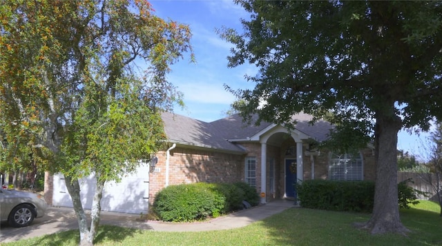 view of property hidden behind natural elements with a front lawn