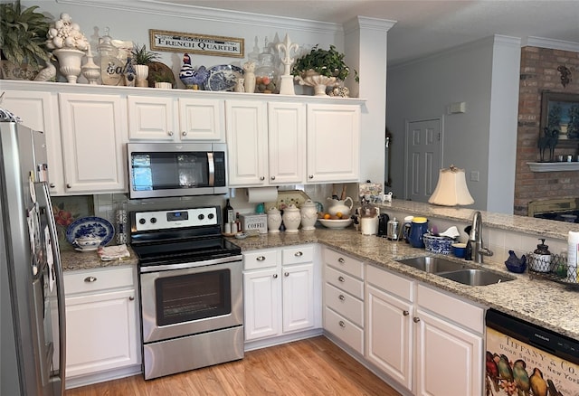 kitchen with white cabinets, sink, ornamental molding, light hardwood / wood-style floors, and stainless steel appliances