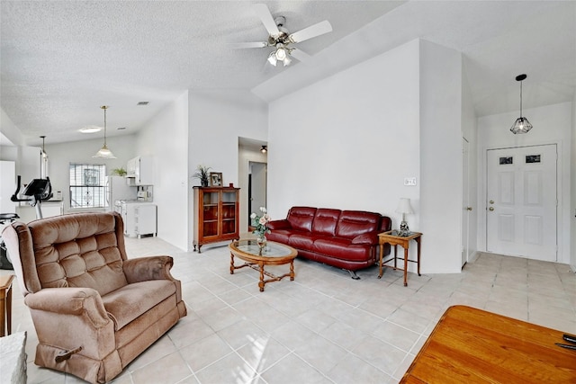 tiled living room with a textured ceiling, ceiling fan, and vaulted ceiling