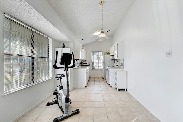 workout room with light tile patterned floors, a textured ceiling, and vaulted ceiling