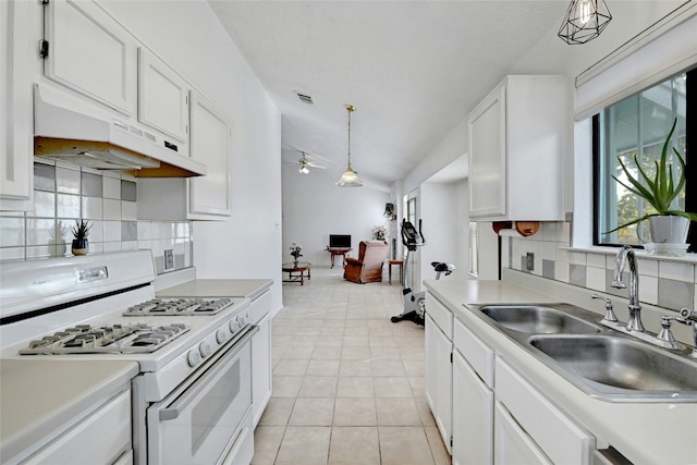 kitchen with sink, range hood, decorative light fixtures, white range with gas cooktop, and white cabinets