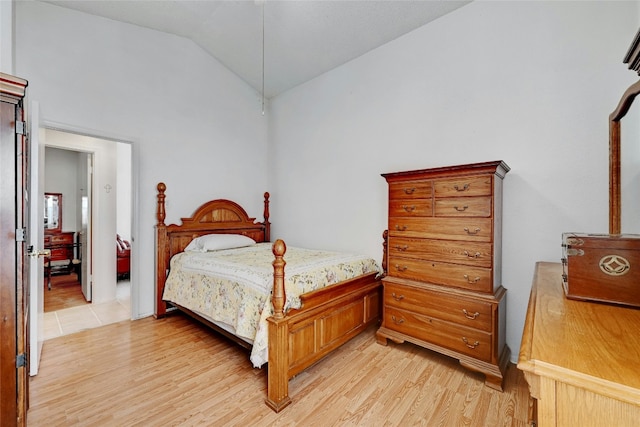 bedroom with light wood-type flooring and vaulted ceiling