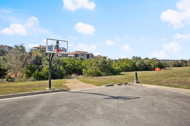 view of sport court with a yard