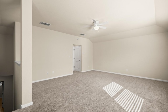 carpeted spare room featuring ceiling fan and lofted ceiling