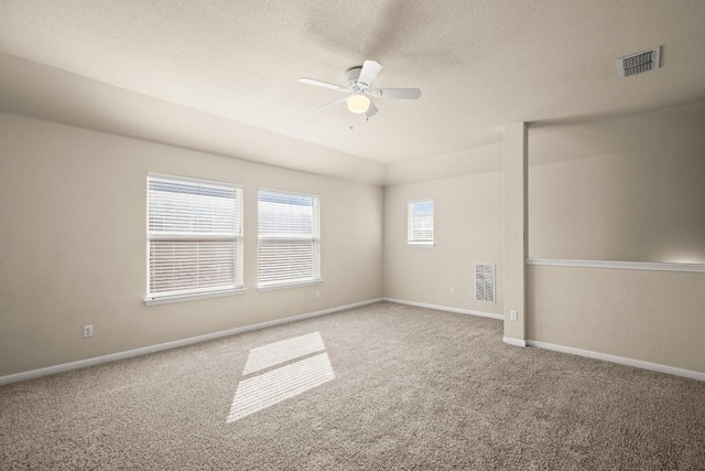 carpeted spare room with ceiling fan and a textured ceiling