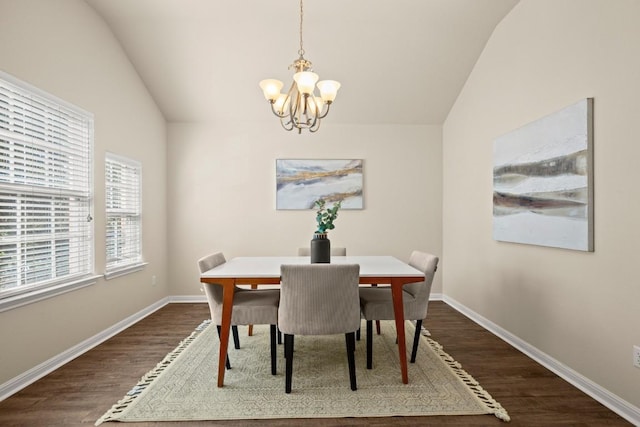 dining area with dark wood-type flooring, lofted ceiling, and a notable chandelier