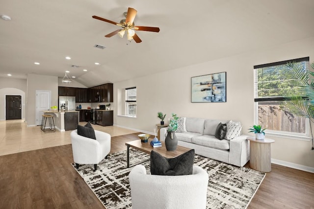 living room with hardwood / wood-style flooring, ceiling fan, and lofted ceiling