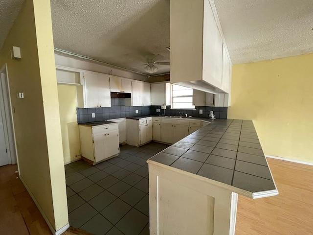 kitchen featuring kitchen peninsula, sink, and a textured ceiling