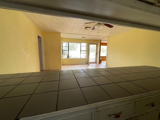 tiled spare room featuring ceiling fan and a textured ceiling