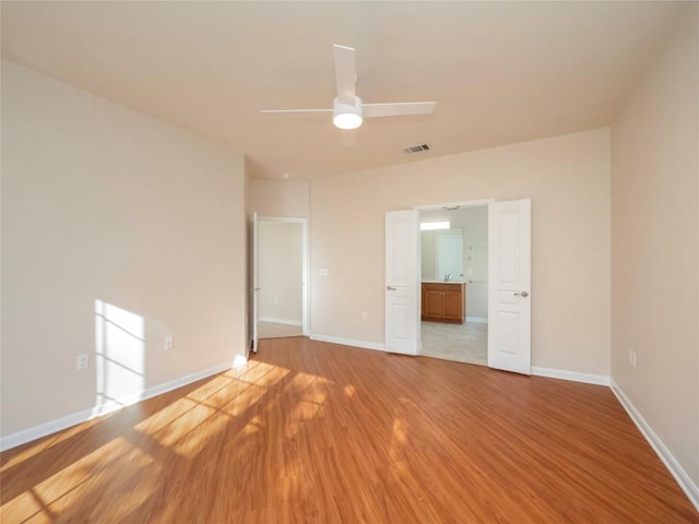 spare room with ceiling fan and light wood-type flooring