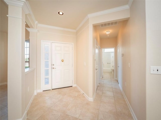 foyer entrance featuring light tile patterned floors and ornamental molding