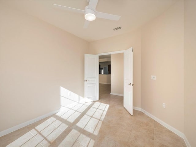 tiled spare room with ceiling fan