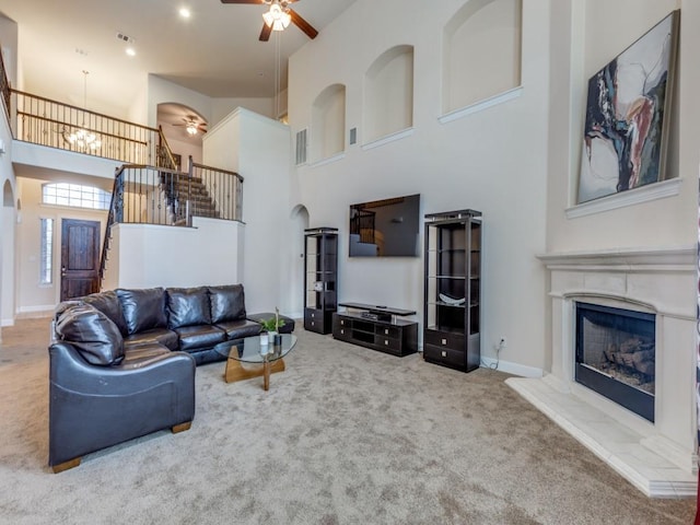 living room with carpet flooring, a towering ceiling, and ceiling fan