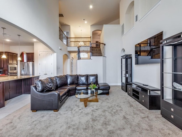 carpeted living room featuring a high ceiling