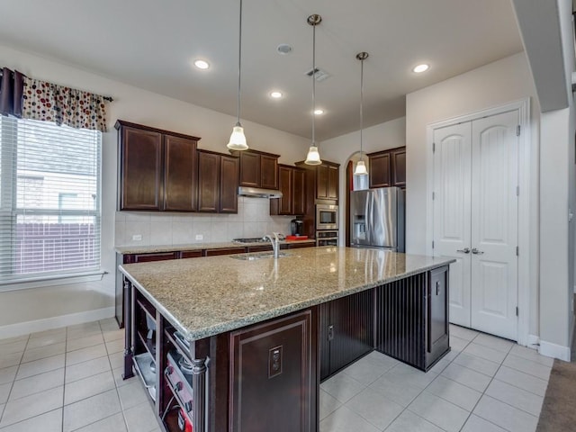 kitchen featuring pendant lighting, backsplash, sink, an island with sink, and appliances with stainless steel finishes