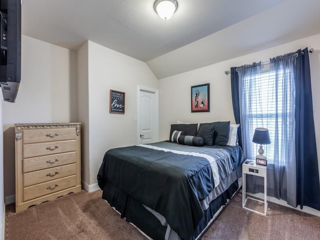 bedroom featuring dark colored carpet and vaulted ceiling