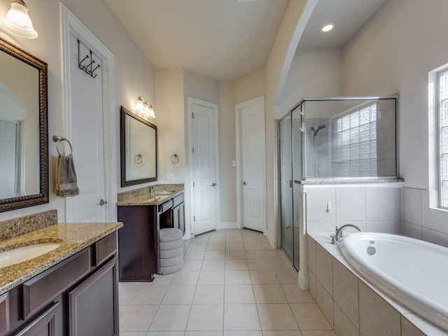 bathroom with plus walk in shower, vanity, and tile patterned flooring