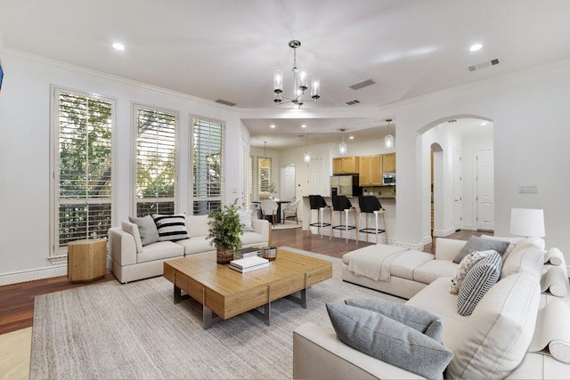 living room featuring crown molding, a chandelier, and light hardwood / wood-style floors