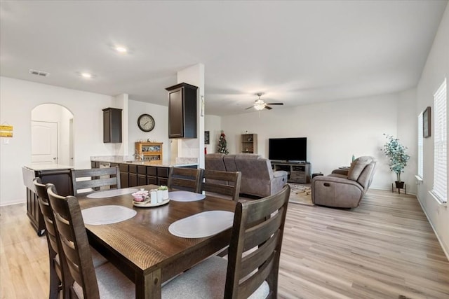 dining space with ceiling fan and light wood-type flooring