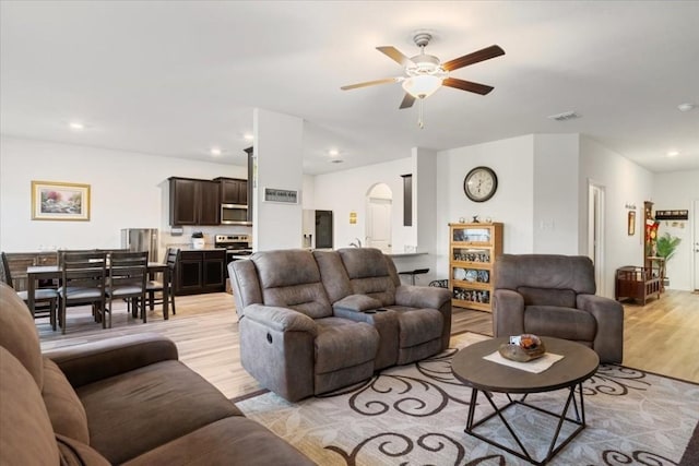 living room with ceiling fan and light hardwood / wood-style flooring