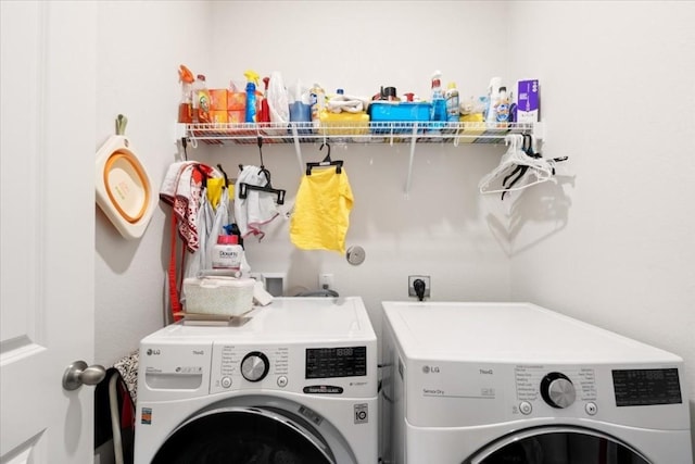 clothes washing area with washer and clothes dryer