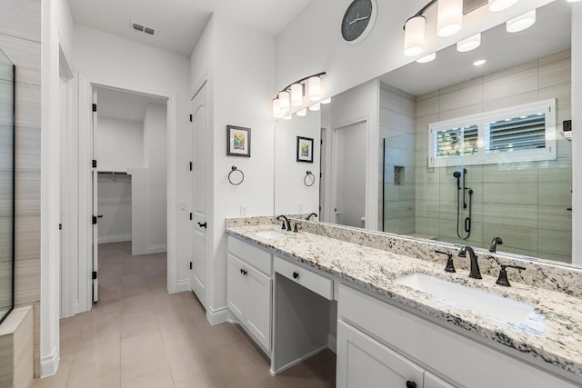 bathroom featuring tile patterned flooring, vanity, and walk in shower