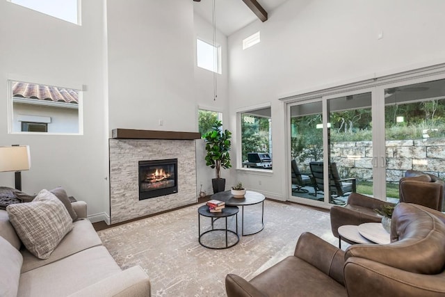 living room featuring beamed ceiling, a towering ceiling, a wealth of natural light, and ceiling fan