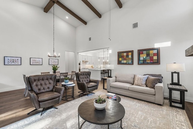 living room featuring beam ceiling, hardwood / wood-style floors, high vaulted ceiling, and a chandelier