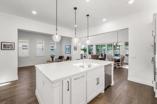 kitchen featuring a kitchen island with sink, sink, pendant lighting, and dark hardwood / wood-style floors