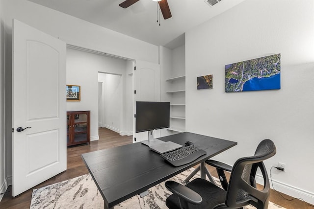 home office with ceiling fan and dark hardwood / wood-style flooring