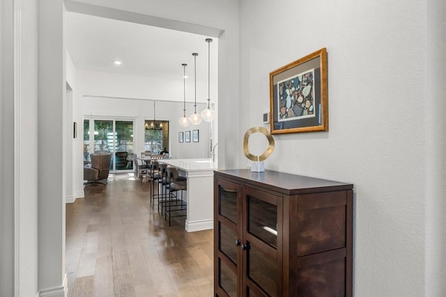 hall with an inviting chandelier and dark wood-type flooring