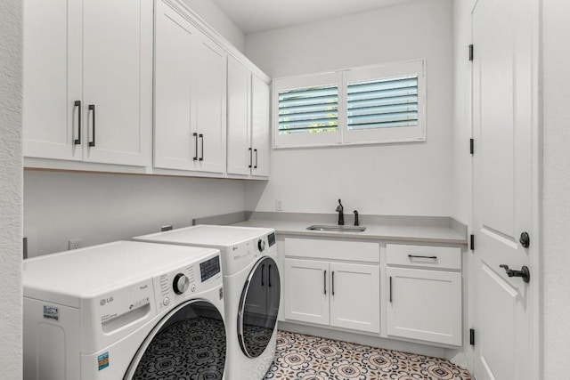 clothes washing area featuring cabinets, washer and clothes dryer, and sink