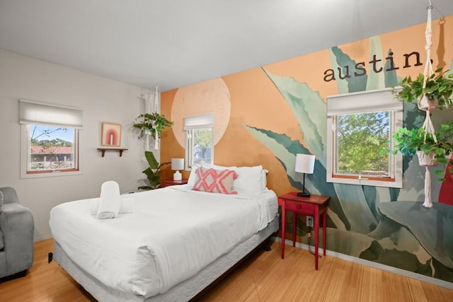 bedroom with wood-type flooring and multiple windows