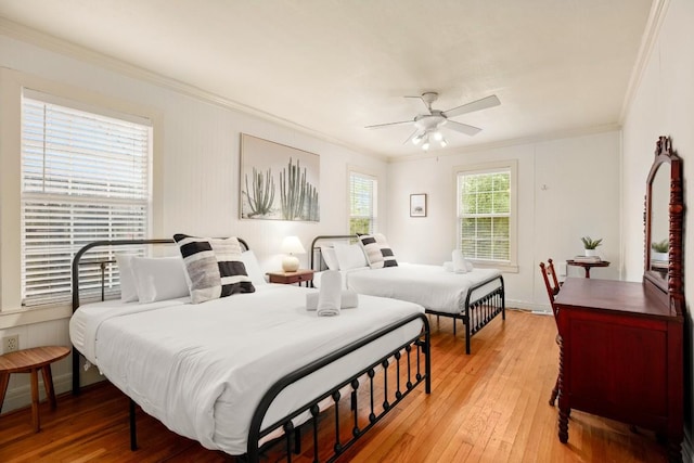 bedroom featuring light hardwood / wood-style floors, ceiling fan, and crown molding