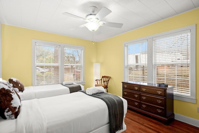 bedroom with multiple windows, dark hardwood / wood-style floors, and ceiling fan