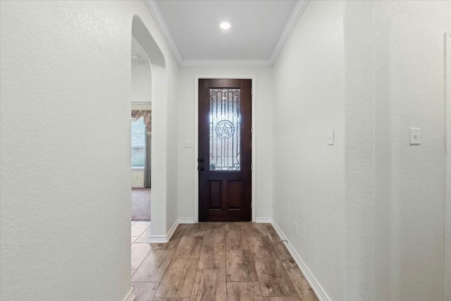 entryway featuring light wood-type flooring and crown molding