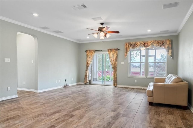 living area with arched walkways, ornamental molding, visible vents, and baseboards