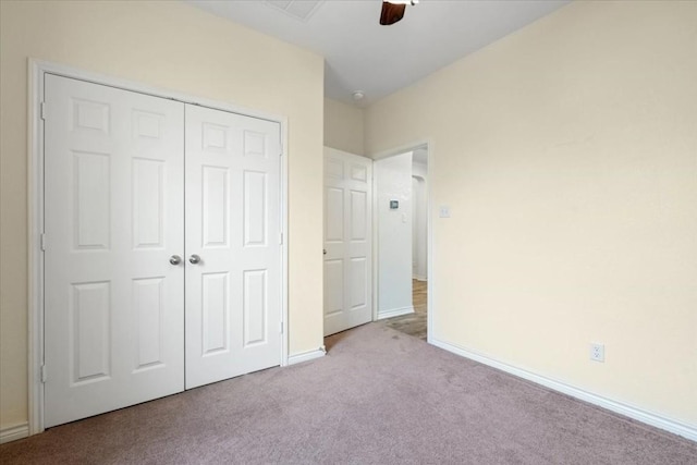 unfurnished bedroom with a ceiling fan, a closet, light colored carpet, and baseboards