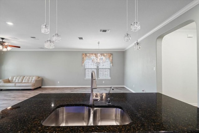 kitchen featuring dark stone counters and hanging light fixtures