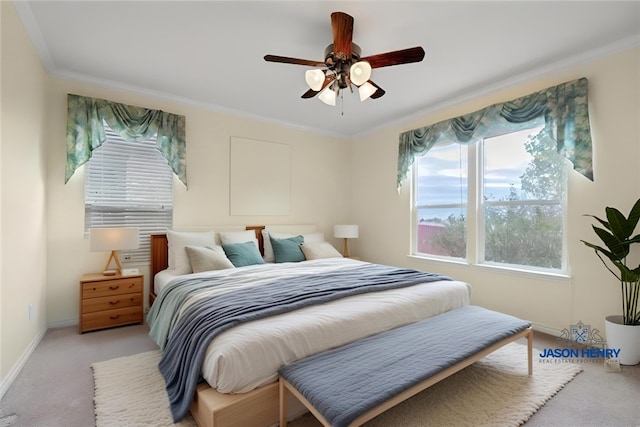 bedroom featuring light carpet, baseboards, ornamental molding, and ceiling fan