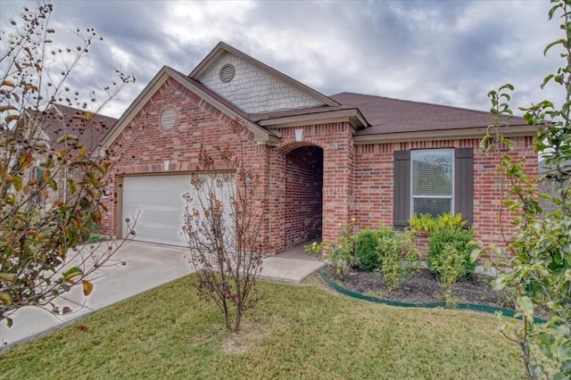 view of front of house featuring an attached garage, driveway, a front yard, and brick siding