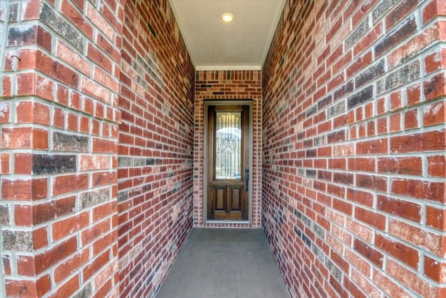 entrance to property featuring brick siding