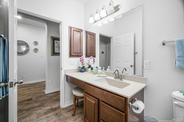 bathroom featuring vanity, baseboards, and wood finished floors