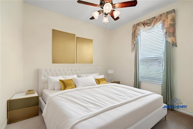 bedroom featuring ceiling fan, multiple windows, baseboards, and light colored carpet