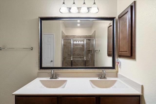 bathroom with double vanity, a stall shower, and a sink