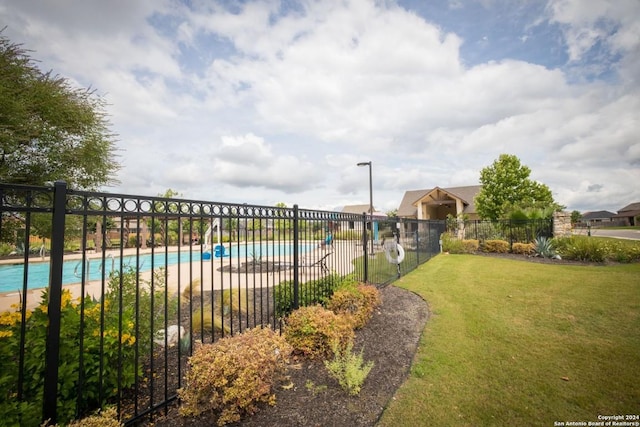 community pool featuring fence and a yard