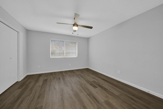 empty room with dark hardwood / wood-style floors and ceiling fan