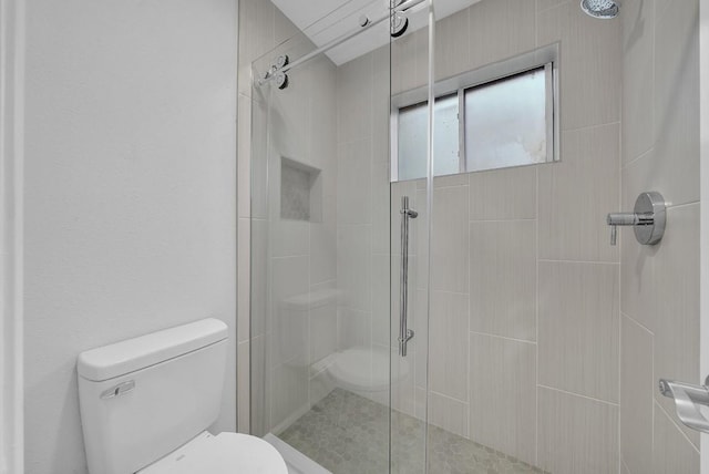 bathroom featuring an enclosed shower and toilet