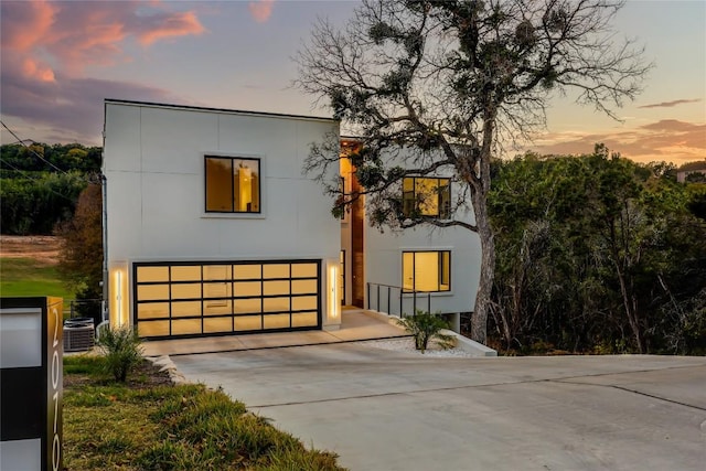 modern home featuring central air condition unit and a garage